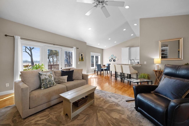 living room with hardwood / wood-style flooring, sink, and vaulted ceiling