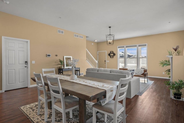 dining room with dark hardwood / wood-style floors and a notable chandelier