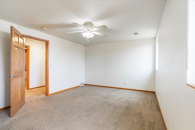 carpeted spare room with ceiling fan