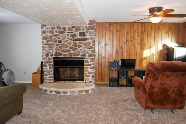 living room featuring carpet floors, a fireplace, and wood walls