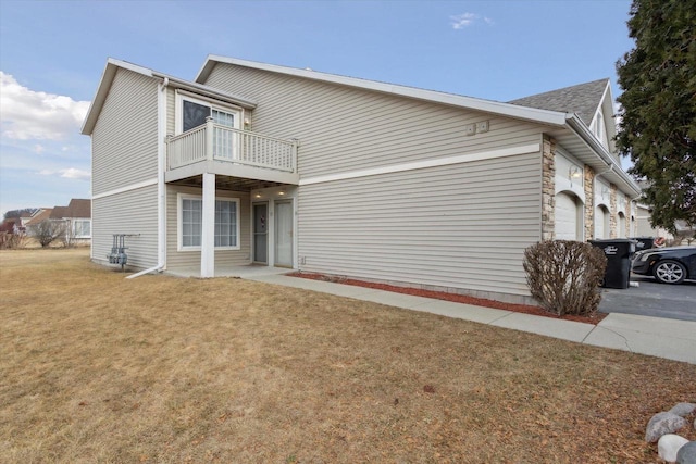 view of side of property with a yard and a balcony