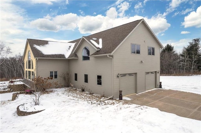 view of snow covered exterior with a garage