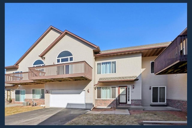 rear view of house featuring a garage and central AC