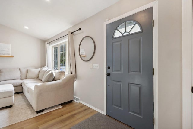 entryway featuring wood-type flooring and vaulted ceiling