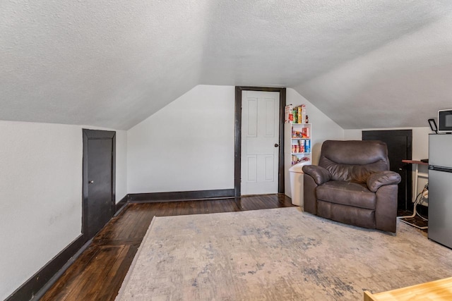 429 W Juneau St, Tomah, WI 54660 - bonus room featuring dark wood-type flooring, a textured ceiling, and vaulted ceiling