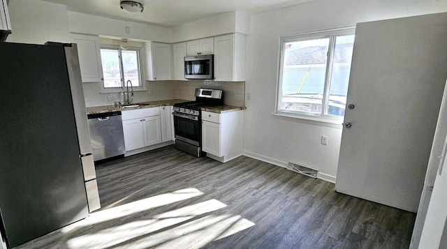 kitchen featuring tasteful backsplash, stainless steel appliances, sink, and white cabinets