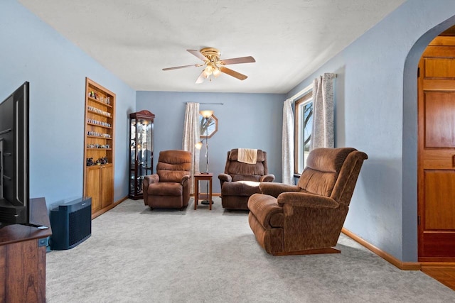 carpeted living room with built in features and ceiling fan