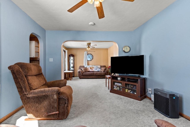 carpeted living room with ceiling fan