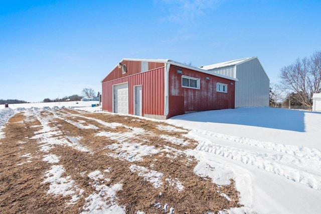 snow covered structure featuring a garage