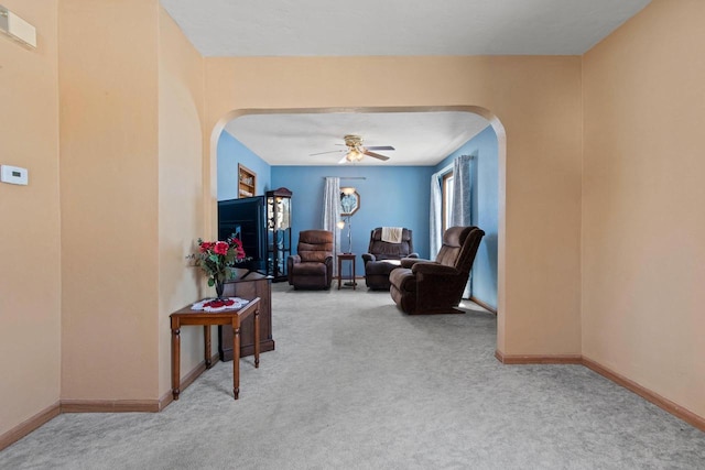 living area with carpet floors and ceiling fan