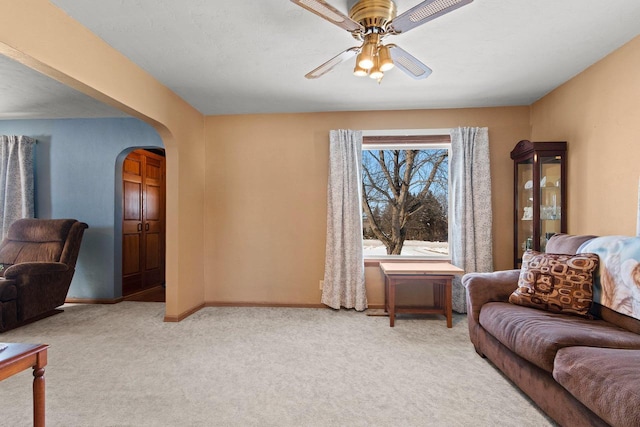 carpeted living room with ceiling fan