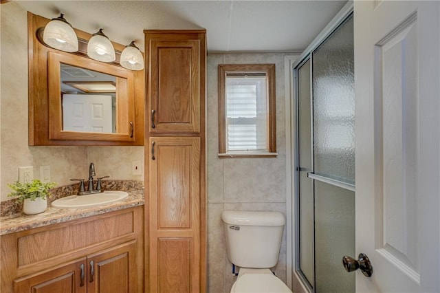 bathroom with a stall shower, vanity, and toilet