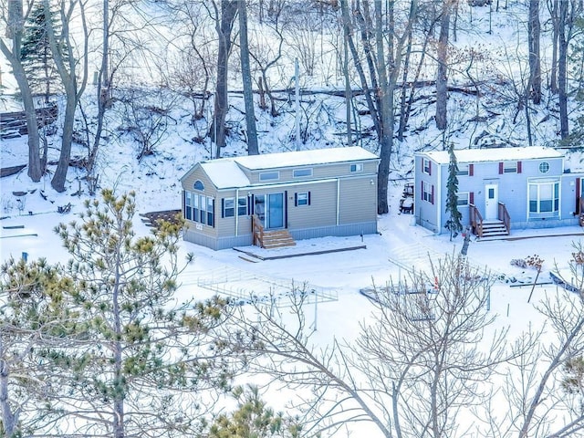 view of snowy property with entry steps