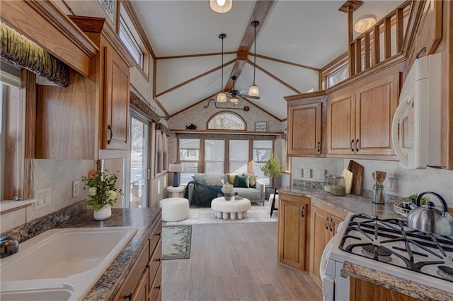 kitchen with white appliances, ceiling fan, beamed ceiling, light wood-type flooring, and a sink