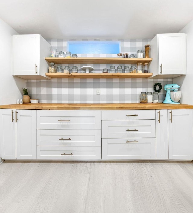 bar featuring white cabinetry, light wood-type flooring, and wood counters