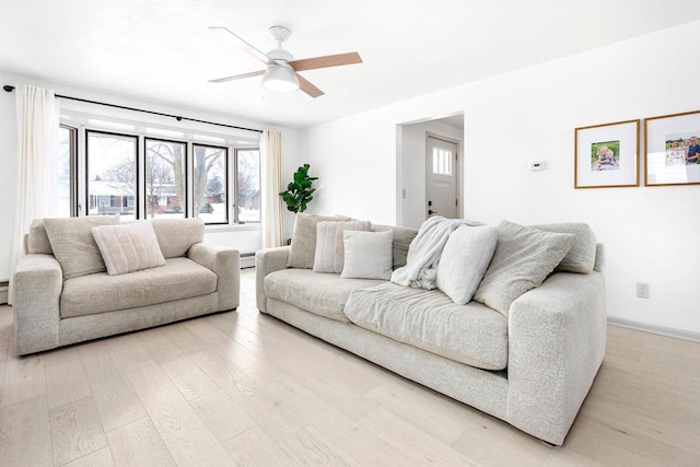 living room with ceiling fan, a baseboard heating unit, and light wood-type flooring