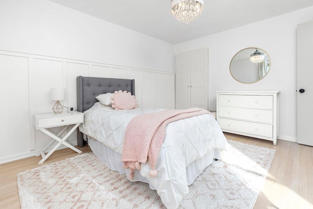 bedroom featuring an inviting chandelier and light hardwood / wood-style flooring