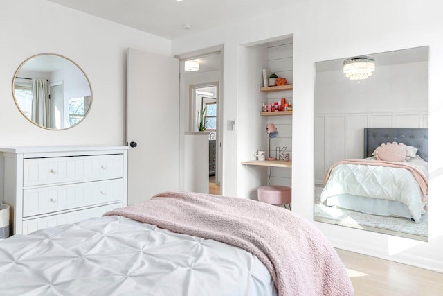 bedroom featuring light hardwood / wood-style floors and a chandelier