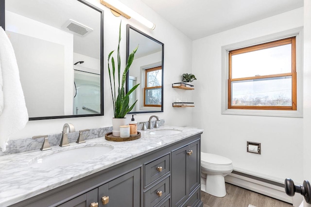 bathroom featuring hardwood / wood-style flooring, vanity, toilet, and baseboard heating