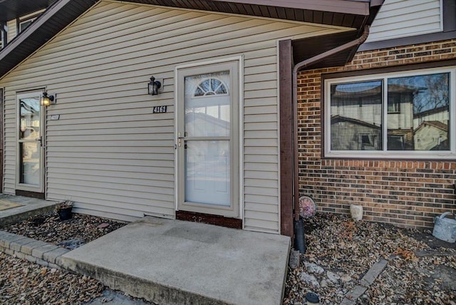 view of exterior entry with a patio area