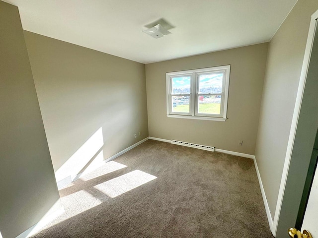 spare room with light carpet and a baseboard heating unit