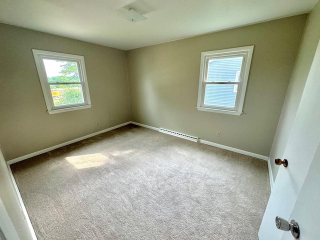 carpeted empty room featuring baseboard heating