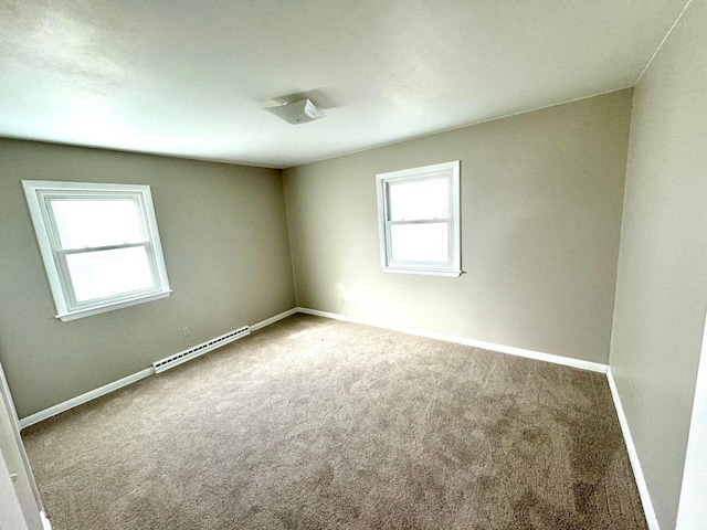 empty room with baseboard heating and carpet floors