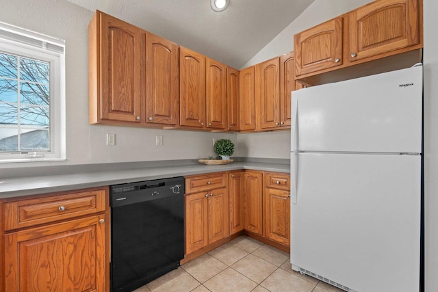 kitchen with lofted ceiling, light tile patterned flooring, black dishwasher, and white fridge