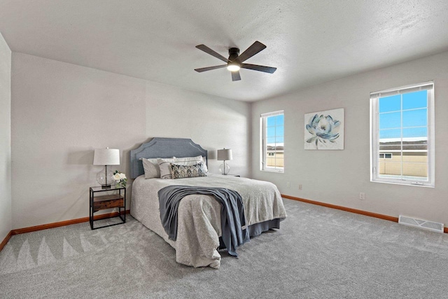 bedroom featuring ceiling fan, carpet flooring, and a textured ceiling