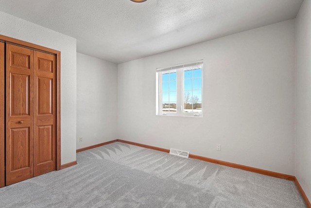 unfurnished bedroom featuring carpet floors and a textured ceiling