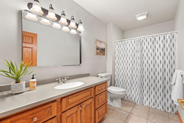 bathroom featuring tile patterned flooring, vanity, toilet, and walk in shower