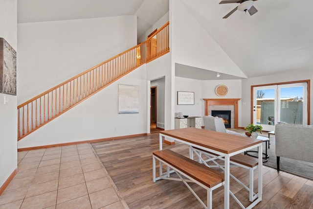 dining space featuring ceiling fan, high vaulted ceiling, and light hardwood / wood-style floors