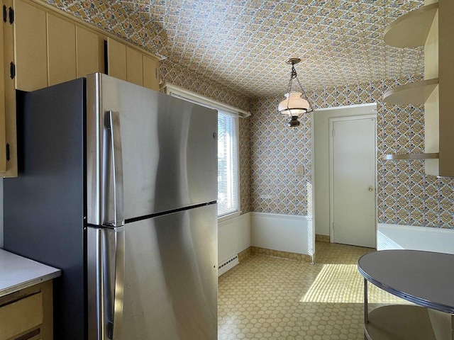 kitchen featuring hanging light fixtures, a baseboard radiator, cream cabinets, and stainless steel fridge