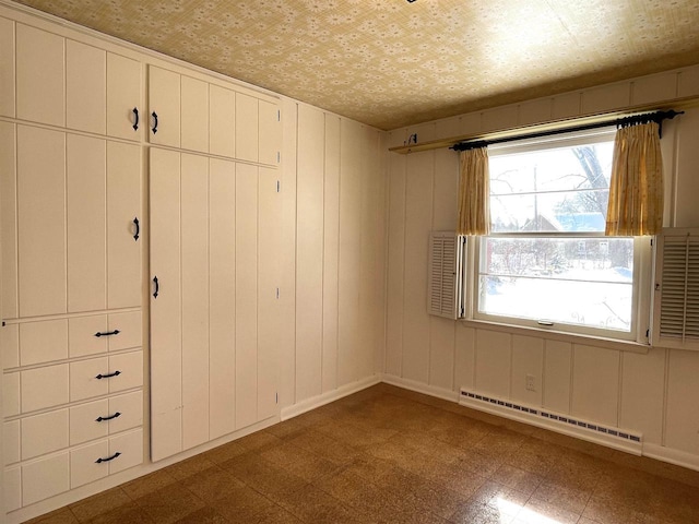 unfurnished bedroom featuring a baseboard heating unit