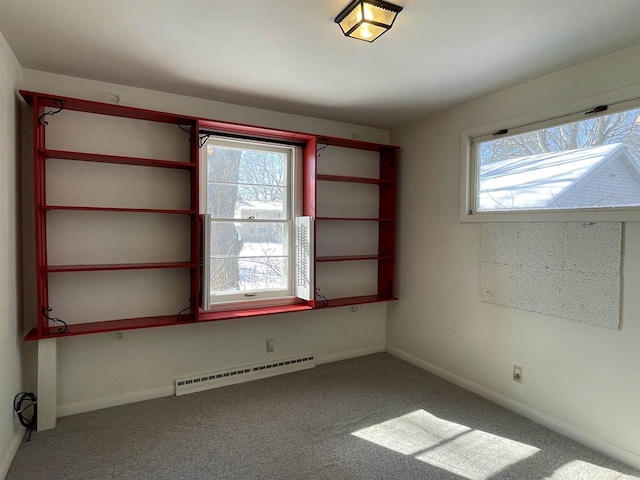 carpeted empty room featuring plenty of natural light and baseboard heating