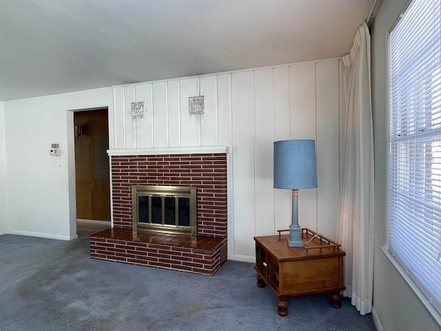 living room featuring dark carpet and a brick fireplace