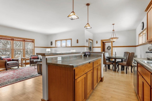 kitchen with decorative light fixtures, a center island, light hardwood / wood-style floors, and a wealth of natural light