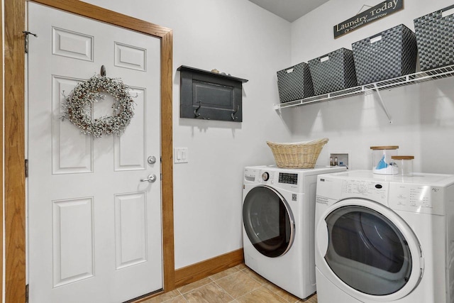 laundry room featuring washing machine and clothes dryer and light tile patterned floors