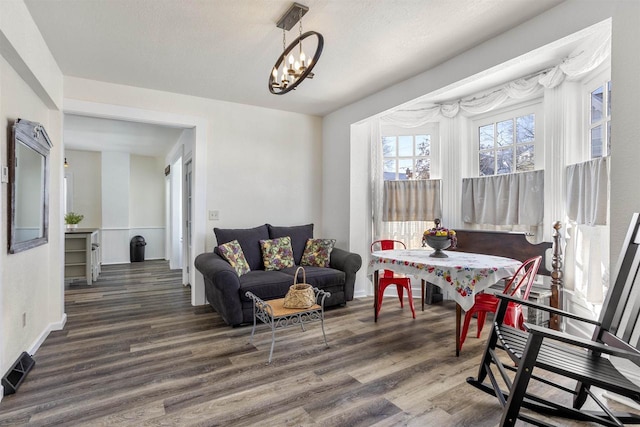 living room featuring an inviting chandelier and dark hardwood / wood-style flooring