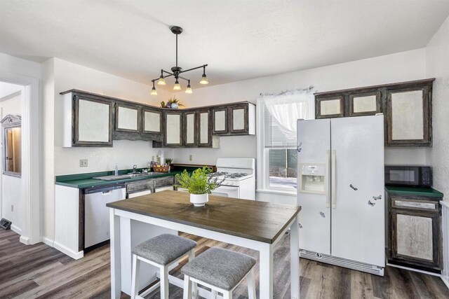 51 W 10th Ave, Oshkosh, WI 54902 - kitchen featuring sink, hanging light fixtures, dark hardwood / wood-style flooring, a kitchen island, and white appliances