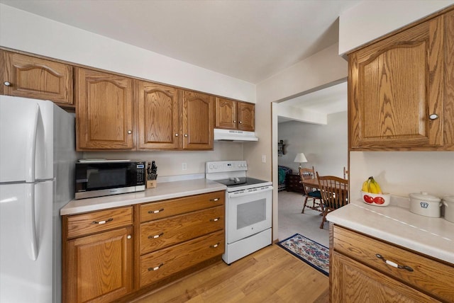 kitchen featuring white appliances and light hardwood / wood-style flooring