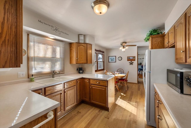 kitchen featuring sink, light hardwood / wood-style flooring, kitchen peninsula, and ceiling fan