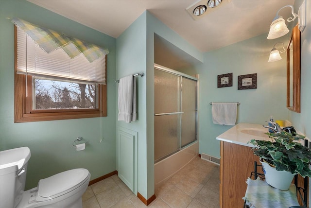 full bathroom with tile patterned flooring, vanity, combined bath / shower with glass door, and toilet