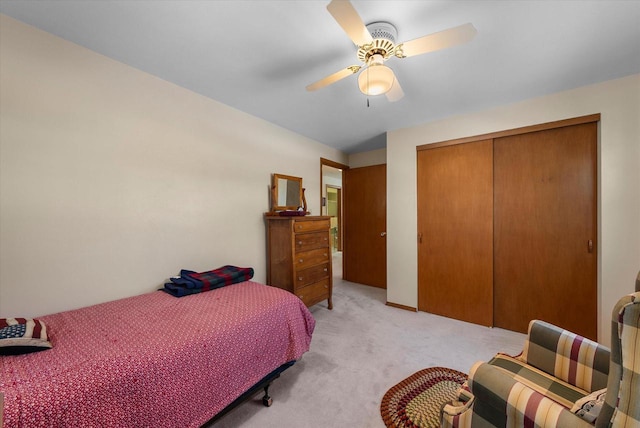 carpeted bedroom with ceiling fan and a closet