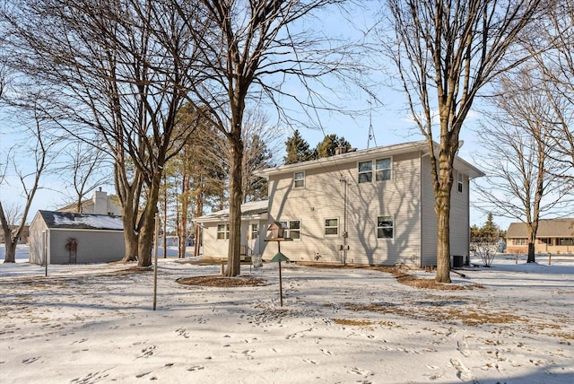 snow covered property featuring an outbuilding