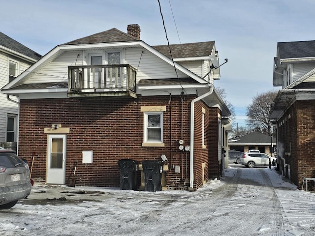 view of snow covered exterior with a balcony