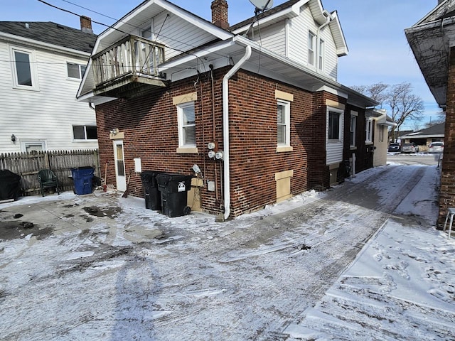 view of snowy exterior featuring a balcony