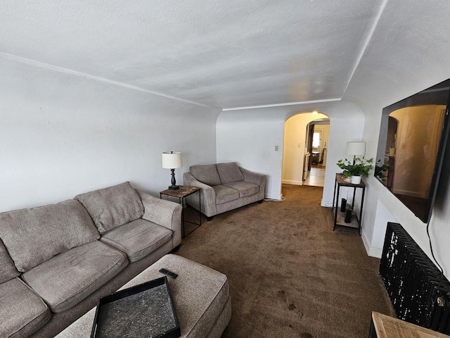 living room featuring a textured ceiling and dark carpet