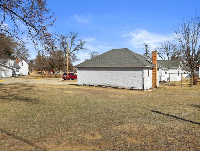 505 S Howard St, Princeton, WI 54968 - view of side of property with a lawn, a chimney, roof with shingles, and brick siding