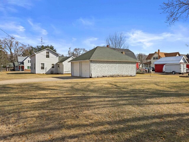 505 S Howard St, Princeton, WI 54968 - view of property exterior with a detached garage, a lawn, and a residential view